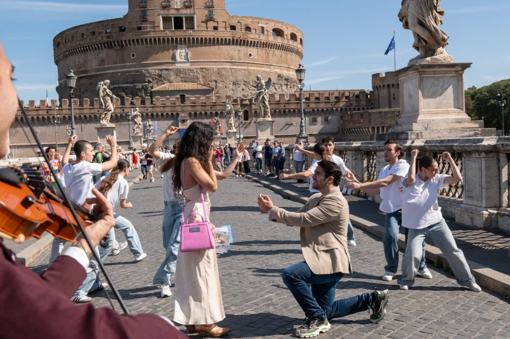 Raul proposing to Cris during a marriage proposal flash mob on Ponte Sant'Angelo in Rome
