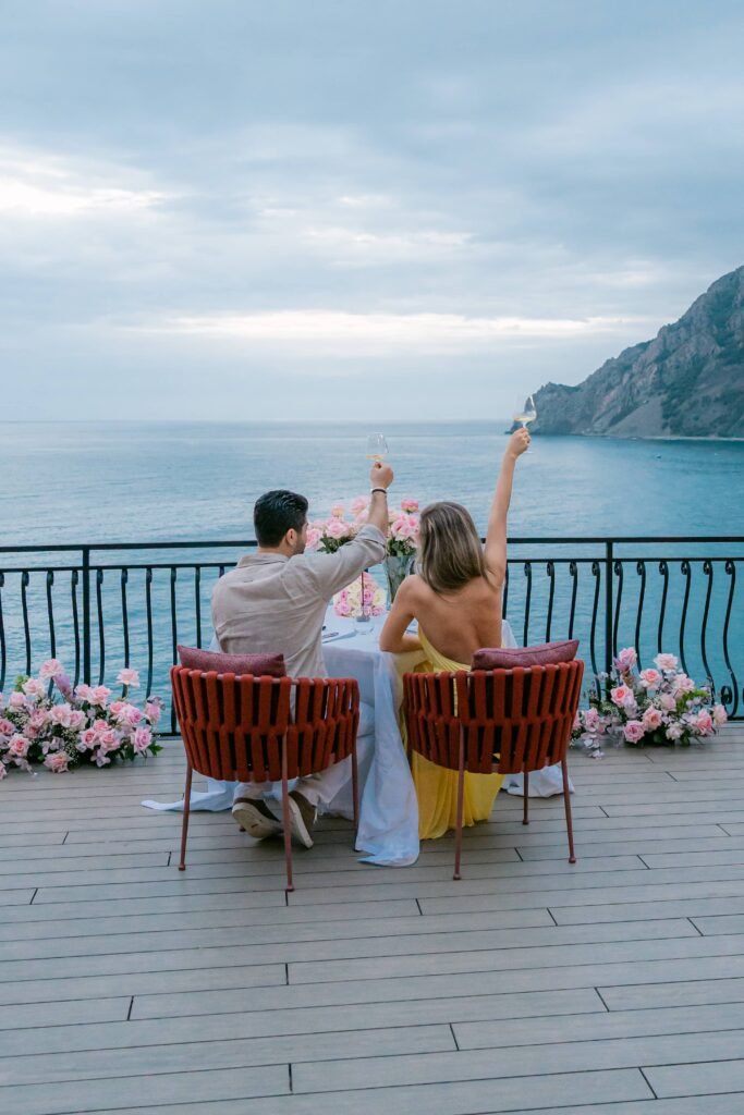 Nicole and Georgio celebrating after their surprise proposal at Porto Roca